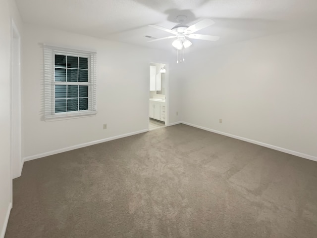 empty room with dark carpet and ceiling fan