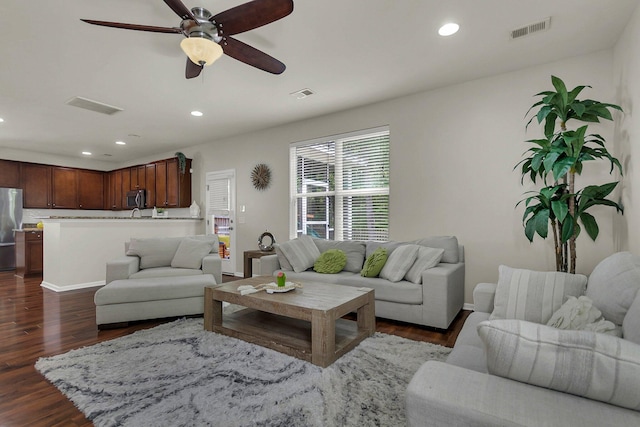 living room featuring ceiling fan and dark hardwood / wood-style flooring