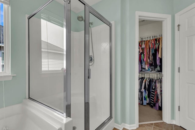 bathroom featuring walk in shower, tile patterned floors, and a healthy amount of sunlight