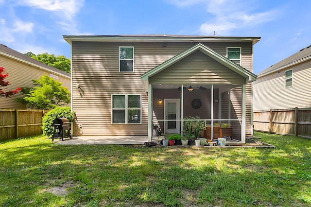 rear view of house featuring ceiling fan, a patio, a sunroom, and a yard