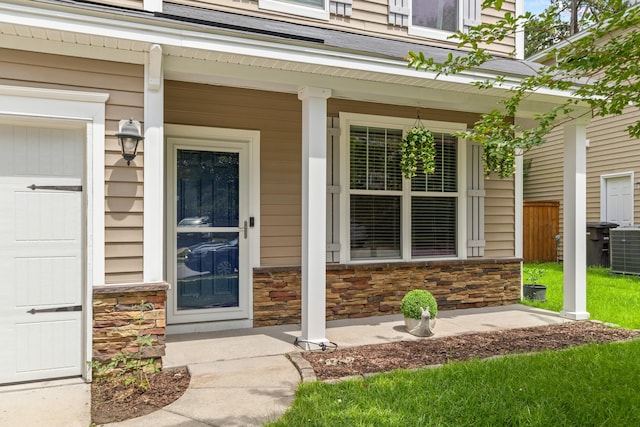 doorway to property featuring a porch and central AC