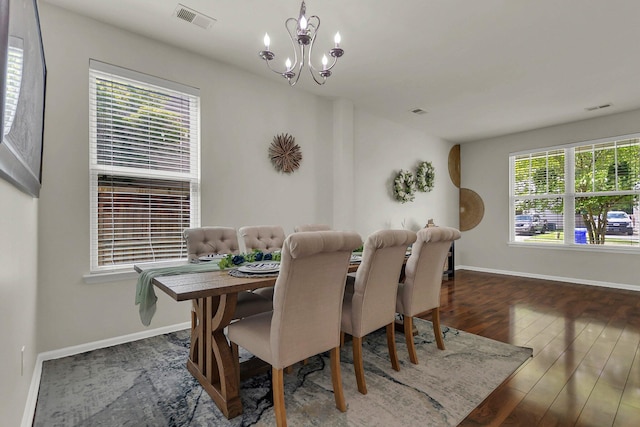 dining space featuring dark hardwood / wood-style floors and a chandelier