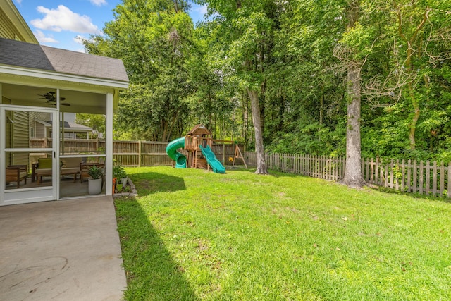 view of yard with ceiling fan, a playground, and a patio