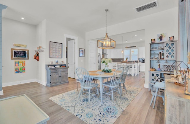 dining room featuring light hardwood / wood-style floors and a notable chandelier