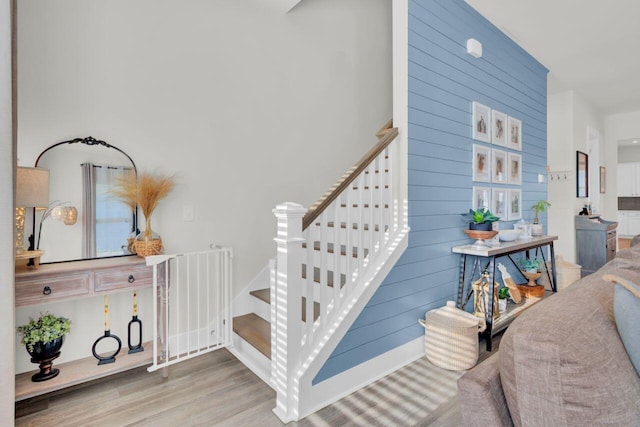 stairs featuring hardwood / wood-style floors and wooden walls