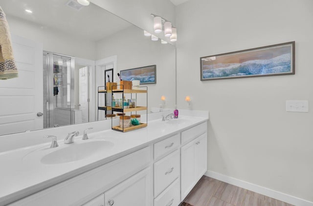 bathroom with hardwood / wood-style flooring, vanity, and a shower with door