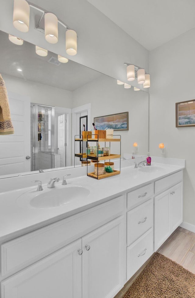 bathroom with hardwood / wood-style floors, vanity, and an enclosed shower