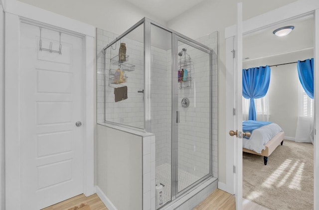 bathroom featuring hardwood / wood-style flooring and a shower with shower door