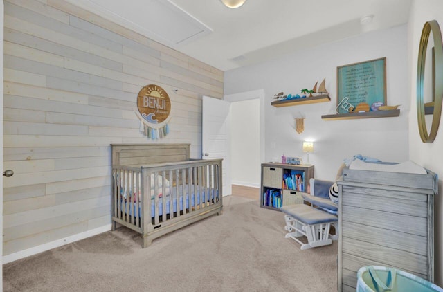 bedroom with wood walls, a crib, and carpet floors