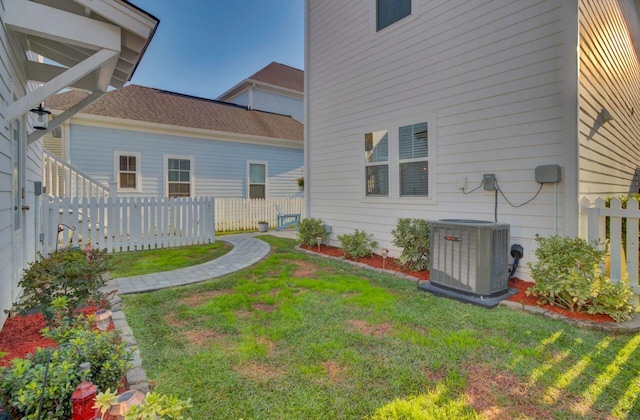 rear view of house with a yard and cooling unit