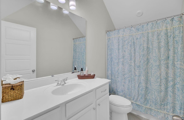 bathroom with vanity, toilet, and lofted ceiling