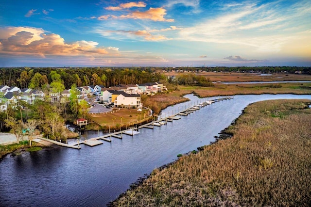 aerial view at dusk featuring a water view