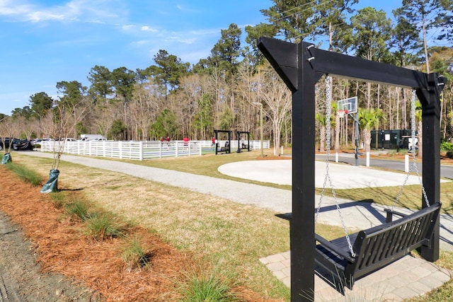 view of property's community featuring a lawn and basketball court