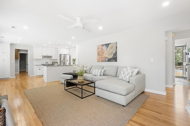 living room with visible vents, baseboards, ceiling fan, recessed lighting, and light wood-style flooring