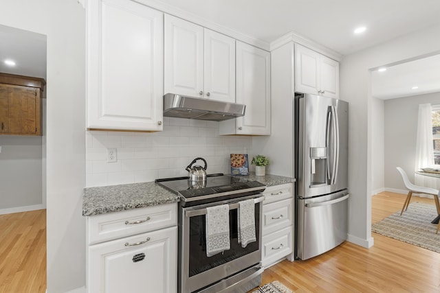 kitchen with light wood finished floors, stainless steel appliances, under cabinet range hood, white cabinetry, and tasteful backsplash