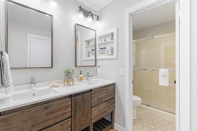 full bathroom featuring double vanity, a shower stall, toilet, and a sink