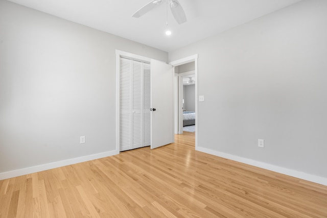 unfurnished bedroom featuring a closet, baseboards, and light wood-style floors