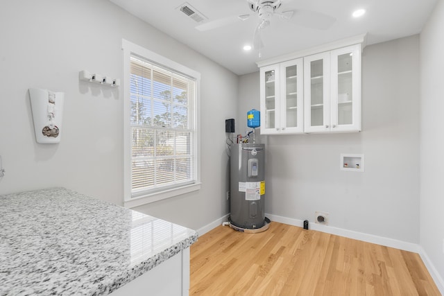 laundry area with visible vents, baseboards, electric water heater, and hookup for a washing machine