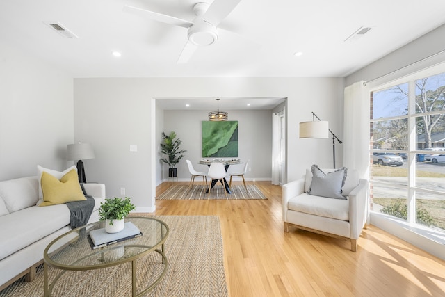 living room with light wood-style floors, a healthy amount of sunlight, and visible vents