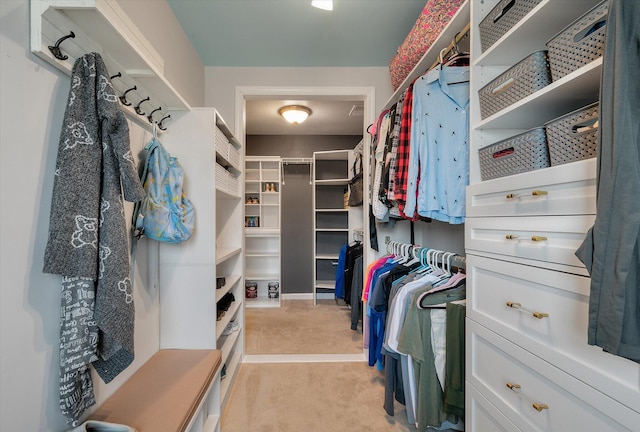 walk in closet featuring light carpet