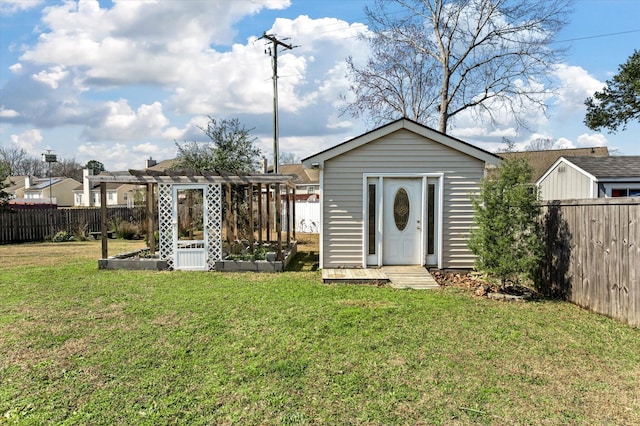 exterior space featuring a vegetable garden, a lawn, a fenced backyard, an outbuilding, and a pergola