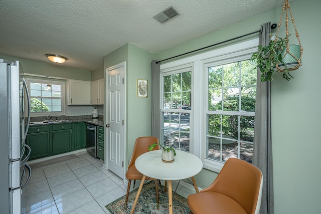 2016 Wild Flower Ln, Charleston, SC 29414 - kitchen with stainless steel appliances, green cabinetry, dark countertops, white cabinetry, and a textured ceiling