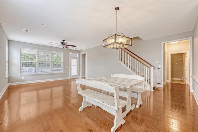 dining space featuring light wood-style flooring, stairway, baseboards, and a ceiling fan