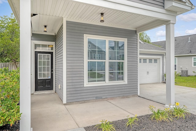 entrance to property with a garage, driveway, and fence