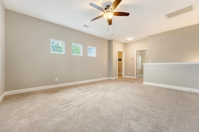 unfurnished room featuring a ceiling fan, light colored carpet, and baseboards