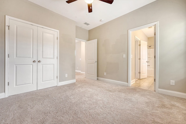 unfurnished bedroom featuring light colored carpet, a closet, baseboards, and a ceiling fan