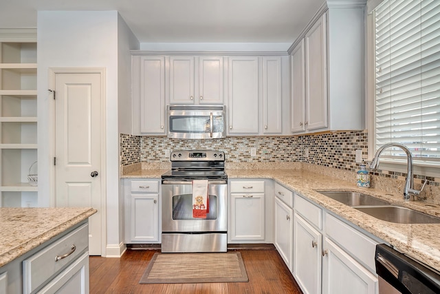 kitchen featuring white cabinets, light stone counters, sink, and appliances with stainless steel finishes