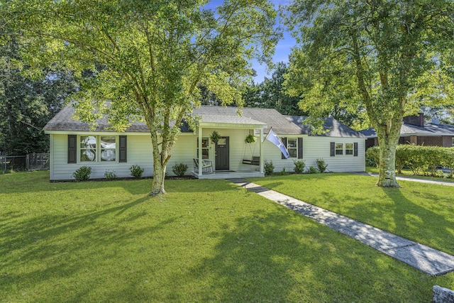 ranch-style home with a front yard and fence