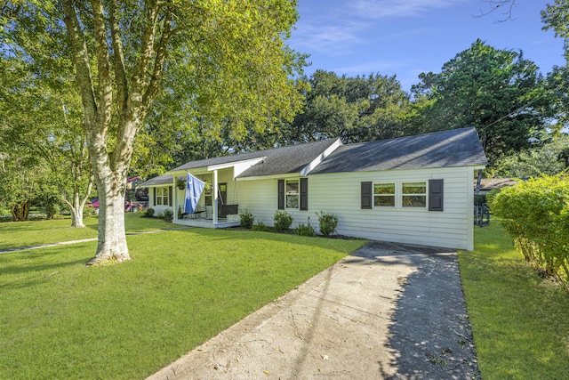 single story home with driveway, covered porch, and a front lawn