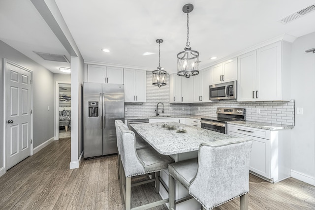 kitchen with light wood finished floors, visible vents, appliances with stainless steel finishes, and a sink