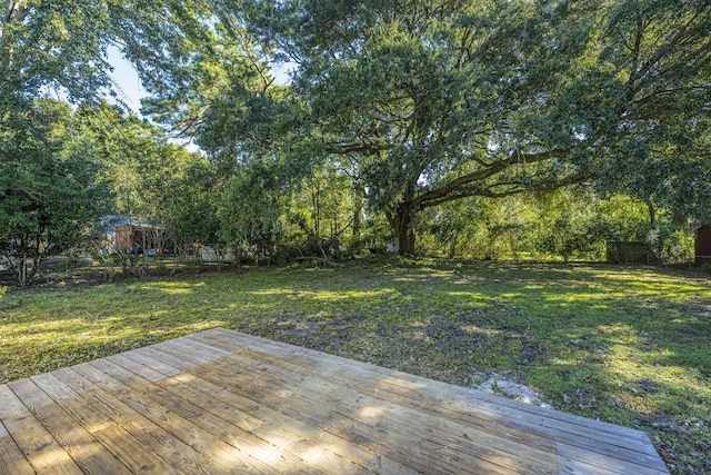 wooden terrace featuring a yard