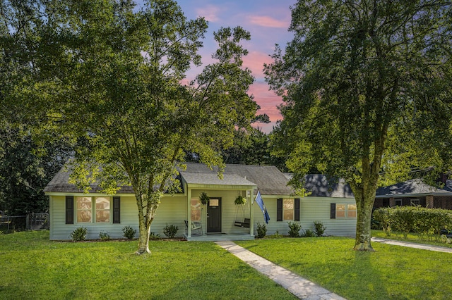 view of front of property featuring a lawn and fence