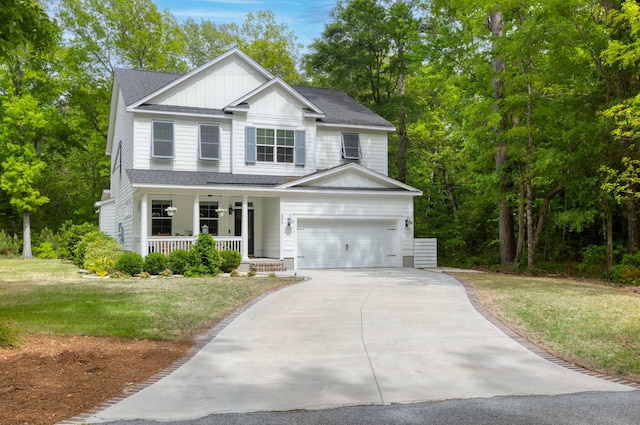 view of front facade featuring covered porch, board and batten siding, driveway, and a front yard