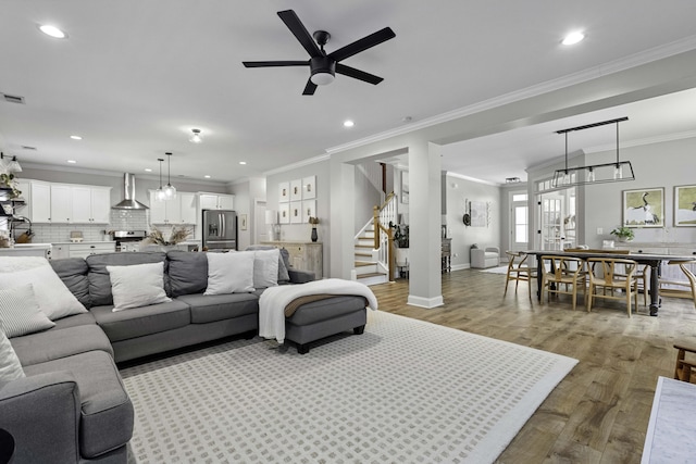 living area with stairs, recessed lighting, a ceiling fan, and wood finished floors