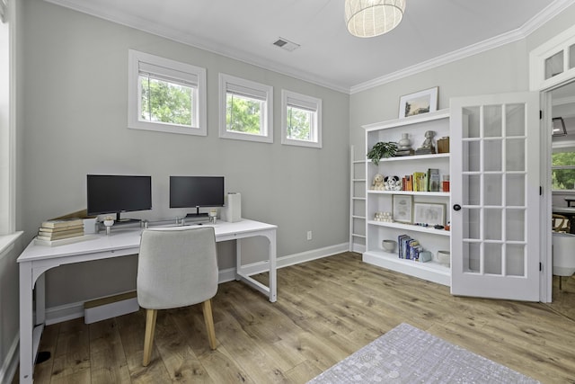 office space featuring crown molding, visible vents, a healthy amount of sunlight, and wood finished floors