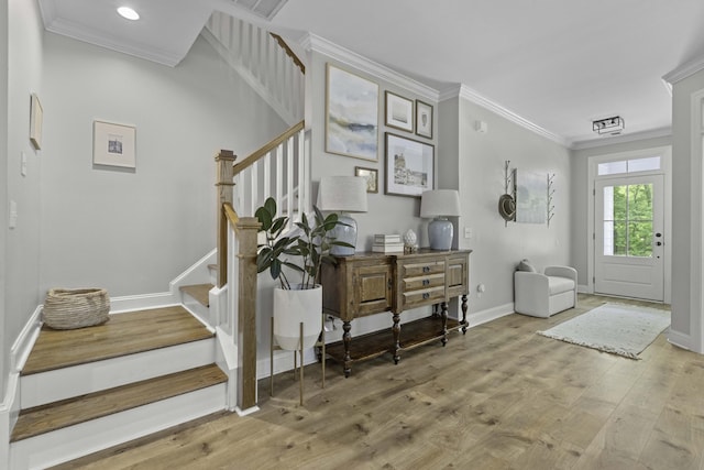 foyer with crown molding, baseboards, stairs, and wood finished floors