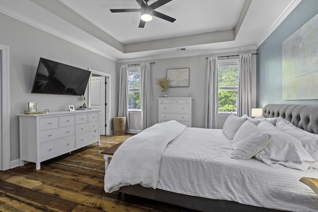 bedroom featuring visible vents, a raised ceiling, dark wood finished floors, and multiple windows