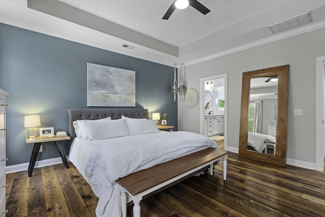 bedroom with crown molding, a tray ceiling, visible vents, and wood finished floors