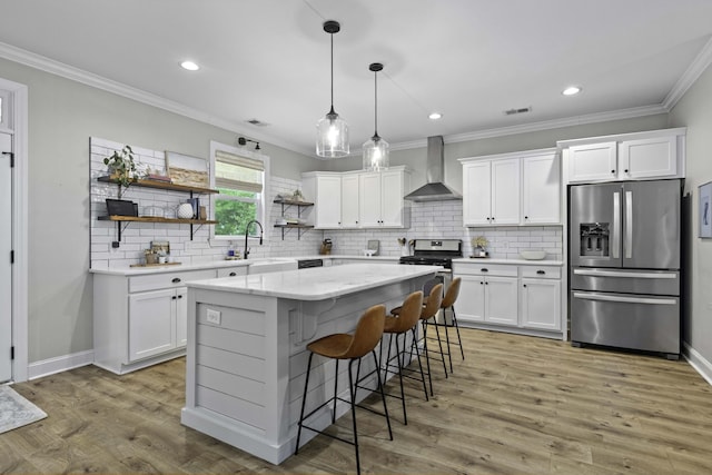 kitchen with open shelves, appliances with stainless steel finishes, wall chimney exhaust hood, white cabinetry, and ornamental molding