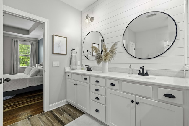 full bath with a sink, baseboards, wood finished floors, and visible vents