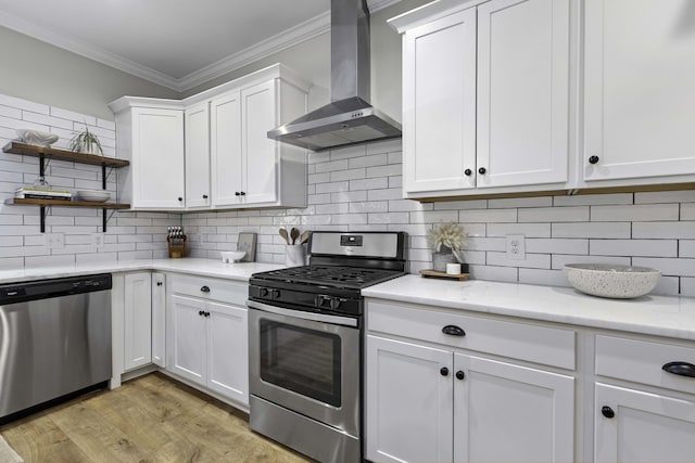 kitchen with wall chimney range hood, crown molding, open shelves, white cabinets, and stainless steel appliances