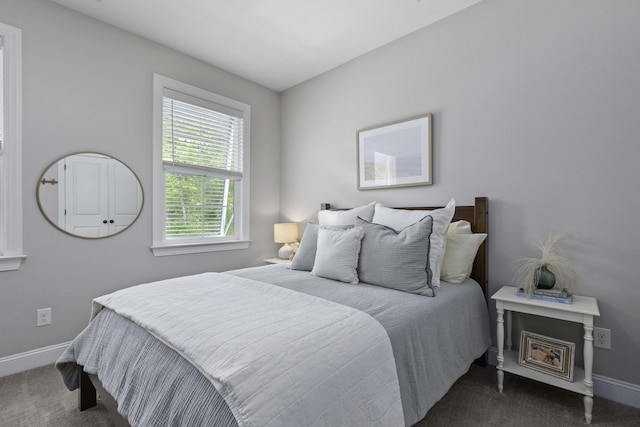 bedroom with baseboards and dark colored carpet