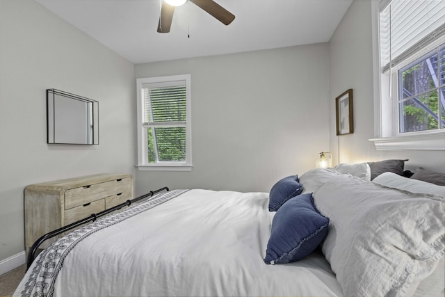 carpeted bedroom featuring baseboards and a ceiling fan