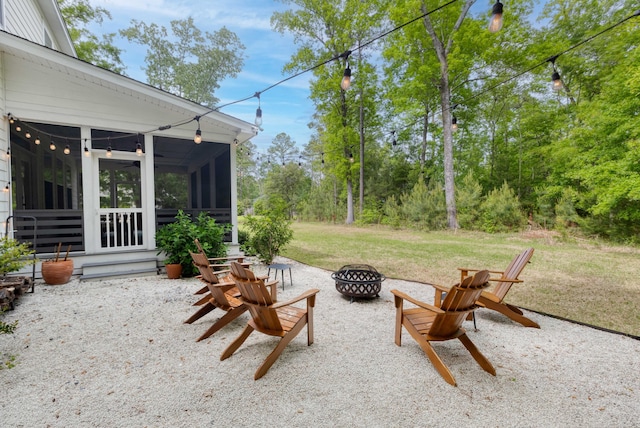 view of patio / terrace with a fire pit and a sunroom