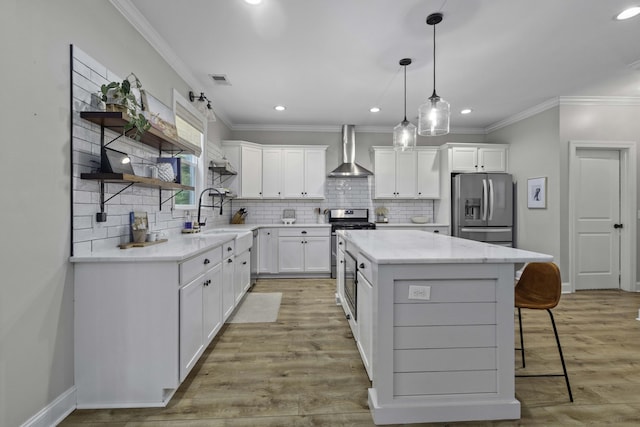 kitchen featuring open shelves, a kitchen island, wall chimney exhaust hood, a sink, and appliances with stainless steel finishes