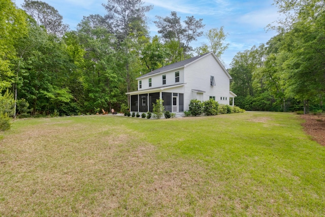 rear view of property with a lawn and a sunroom